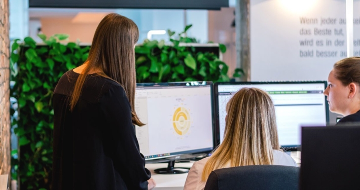 Mitarbeiterinnen gemeinsam vor einem Bildschirm mit Daten