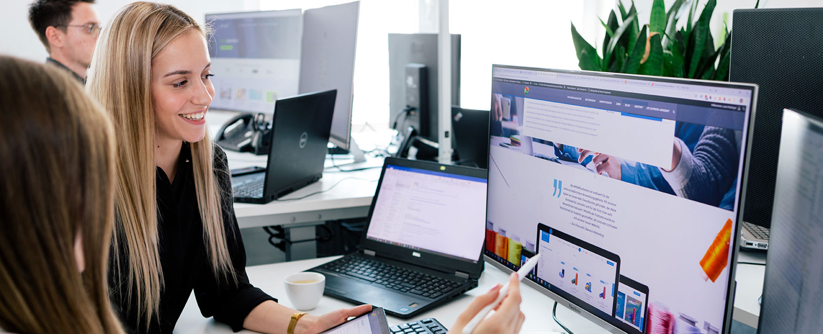 Zwei Mitarbeiter am Arbeitsplatz, besprechen ein Webdesign