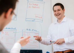 Mitarbeiter vor einem Whiteboard - Besprechung