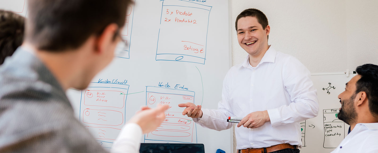 Mitarbeiter vor einem Whiteboard - Besprechung