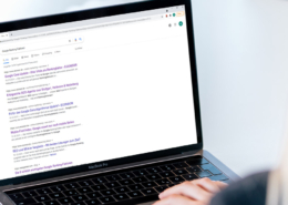Frau sitzt vor Laptop mit offenen Google Suchergebnissen