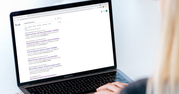Frau sitzt vor Laptop mit offenen Google Suchergebnissen