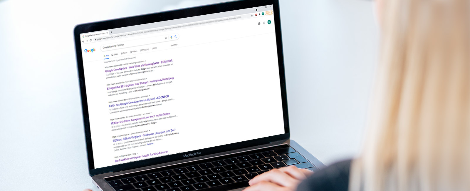 Frau sitzt vor Laptop mit offenen Google Suchergebnissen