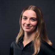 Vanessa Weber Eine junge Frau mit blonden Haaren und schwarzem Shirt blickt lächelnd in Richtung Kamera