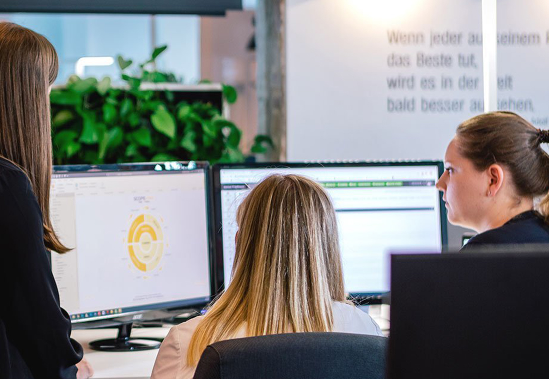 Mitarbeiterinnen gemeinsam vor einem Bildschirm mit Daten