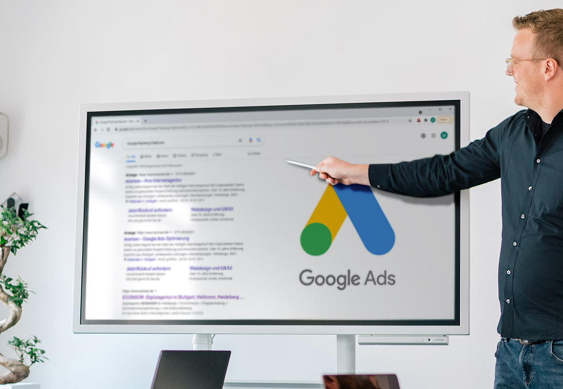Ein Mann zeigt auf Google-Anzeigen, die auf einem weißen Brett skizziert sind.