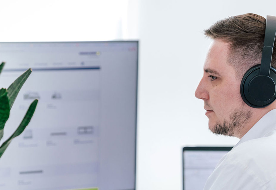 Mitarbeiter von Team TYPO3 am Arbeitsplatz mit Kopfhörern
