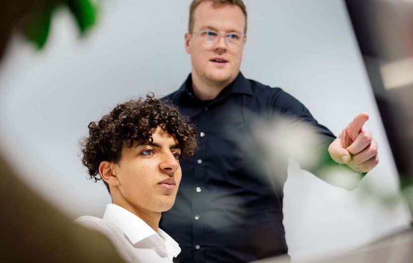Zwei Mitarbeiter arbeiten gemeinsam an einem Computer in der TYPO3-Agentur