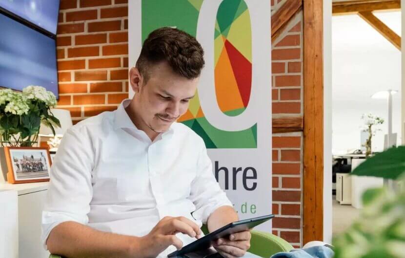Kollege sitzt an einem Tablet und prüft die Conversion-Rate