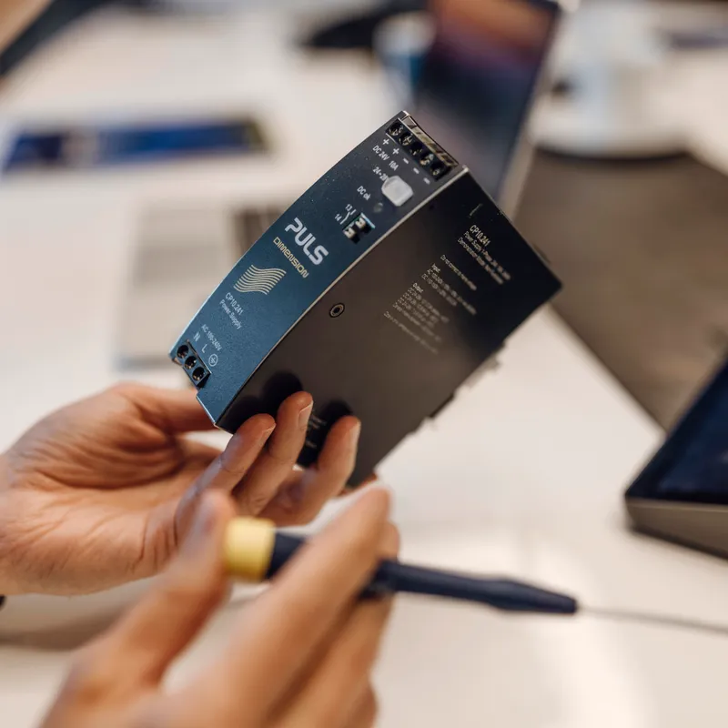 Mitarbeiter hält ein PULS-Produkt in seiner Hand