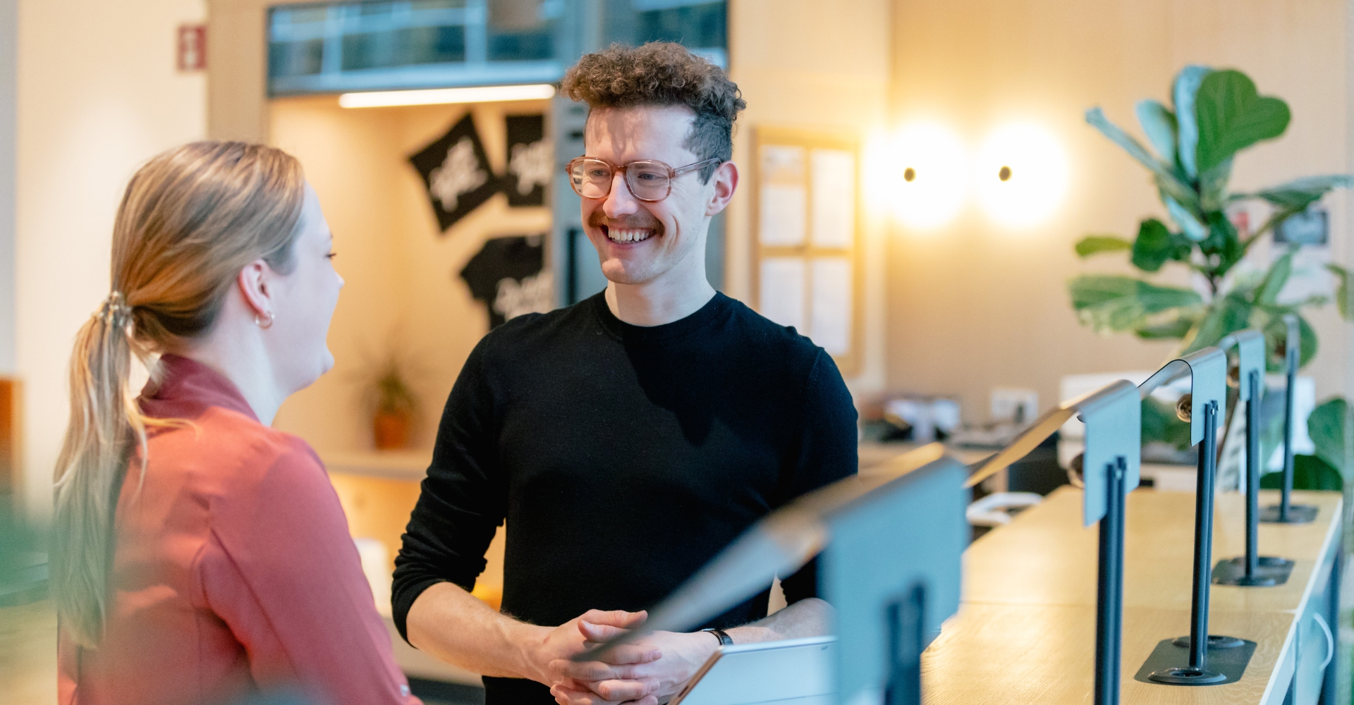 Zwei Mitarbeiter unterhalten sich im Büro in München.