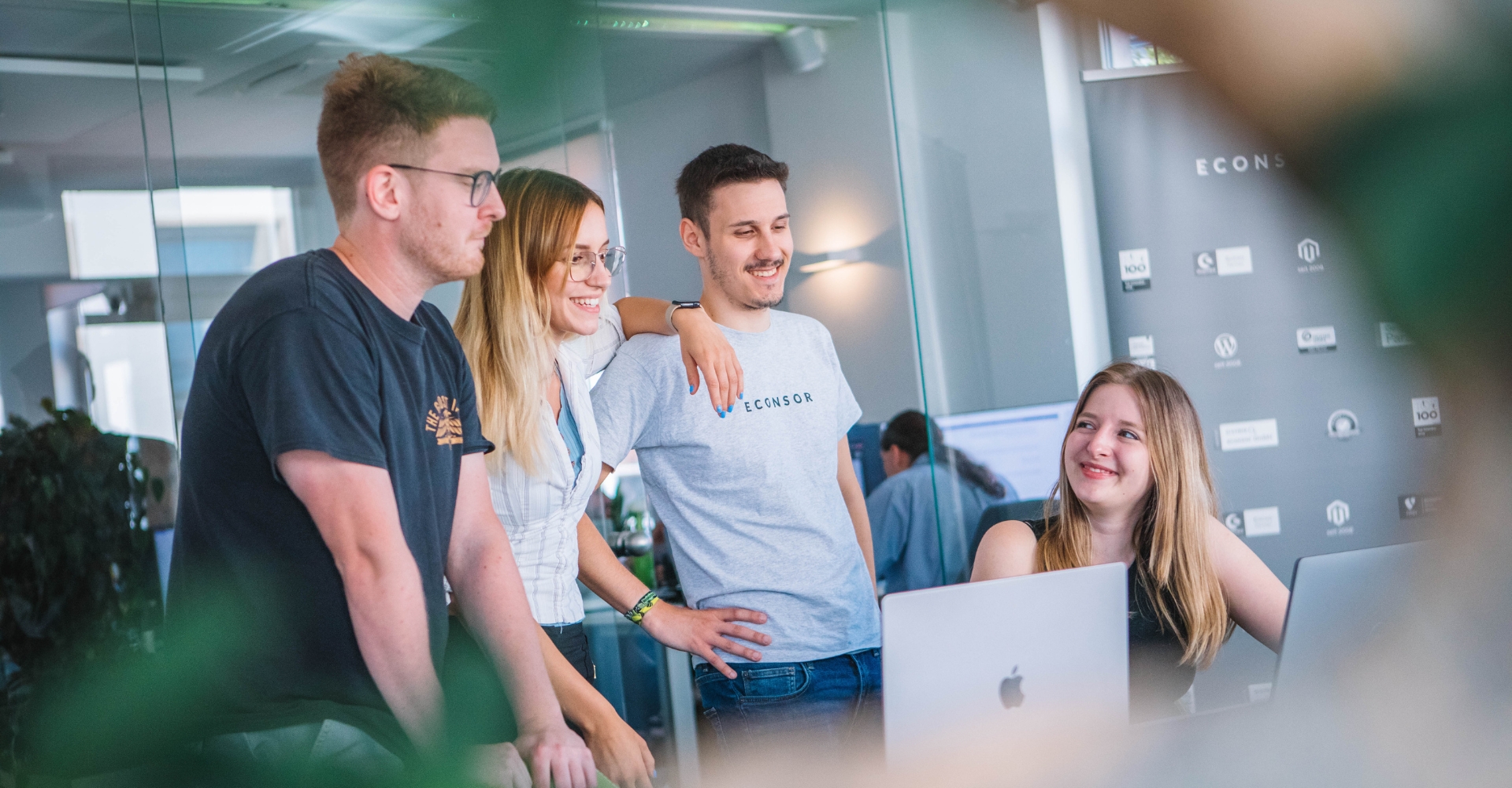 Teammeeting: Vier Kollegen diskutieren ein Projekt am Computer