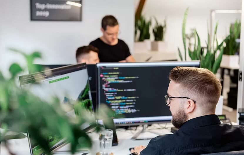 Mitarbeiter im Büro während der Fokus auf einem liegt, welcher programmiert
