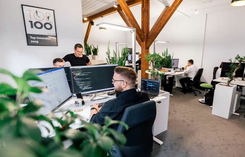 Ein interdisziplinäres Team aus Webdesign- und Webentwicklungsexperten kombiniert UI/UX-Expertise und technische Umsetzung in einem modernen Büro – Symbol für ganzheitliche digitale Projekte.