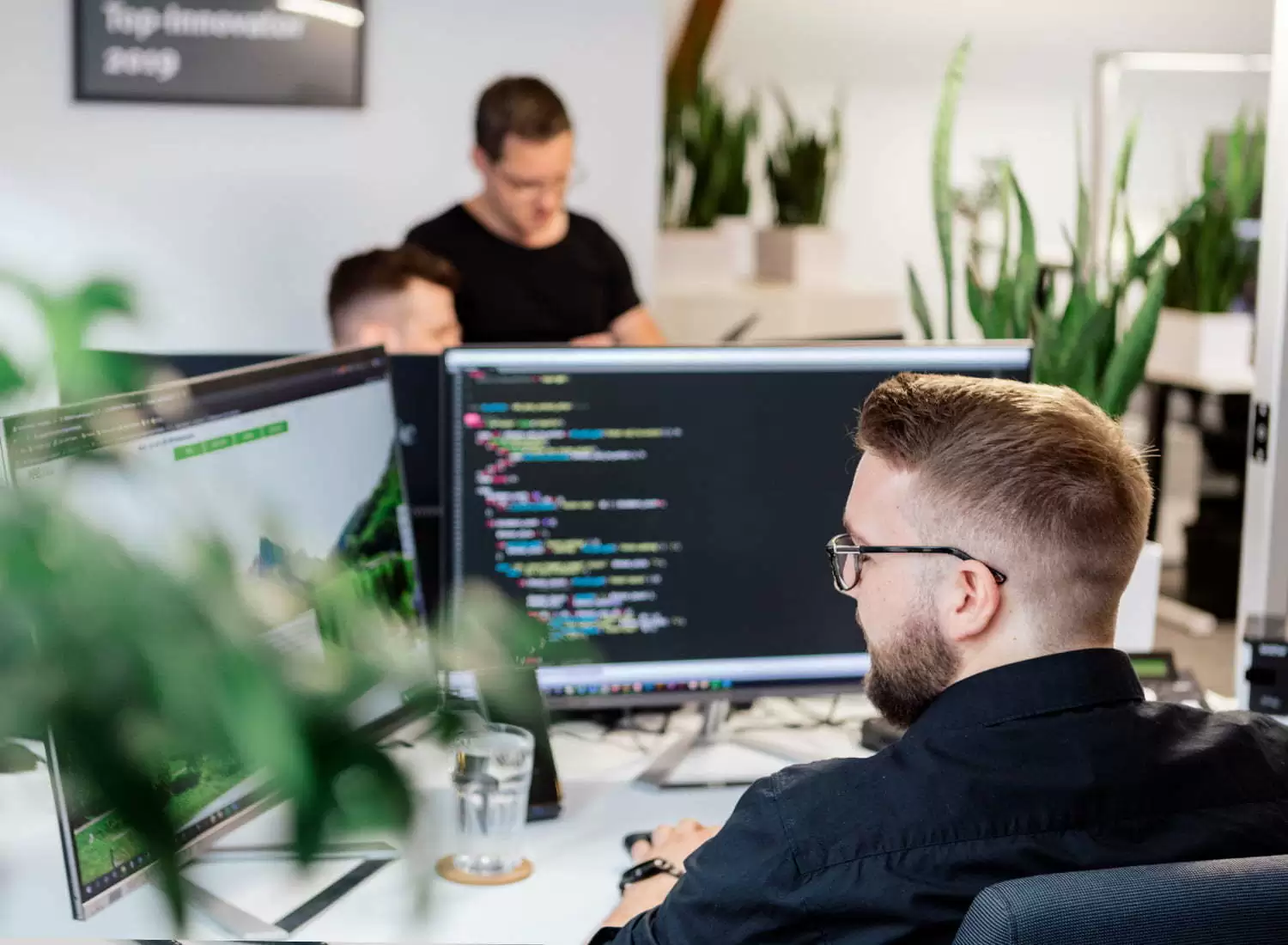 wordpress-buero.jpg Ein Entwickler arbeitet an Monitoren mit Programmcode im ECONSOR-Büro.
