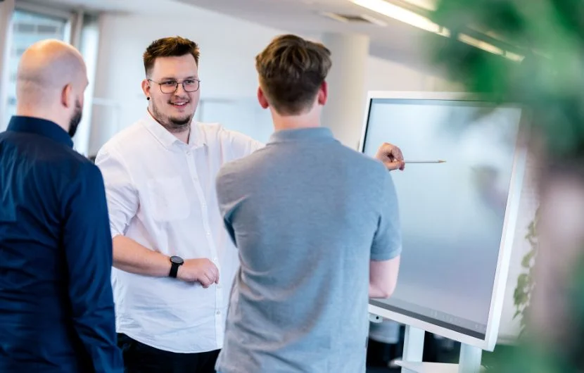 Drei Agenturmitarbeiter entwickeln gemeinsam vor einem Whiteboard digitale Strategien – Ihre Agentur für Web Consulting und Strategie.