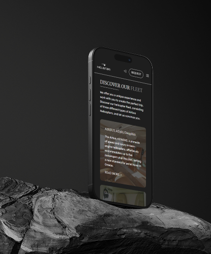 Ein Smartphone steht hochkant auf einem düsteren und unebenem Stein. Auf dem Bildschirm des Smartphones ist die HELISTAR-Website abgebildet.