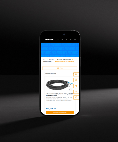 Ein Smartphone steht hochkant auf einem düsteren und unebenem Stein. Auf dem Bildschirm des Smartphones ist der KÖNITZER-Shop abgebildet.