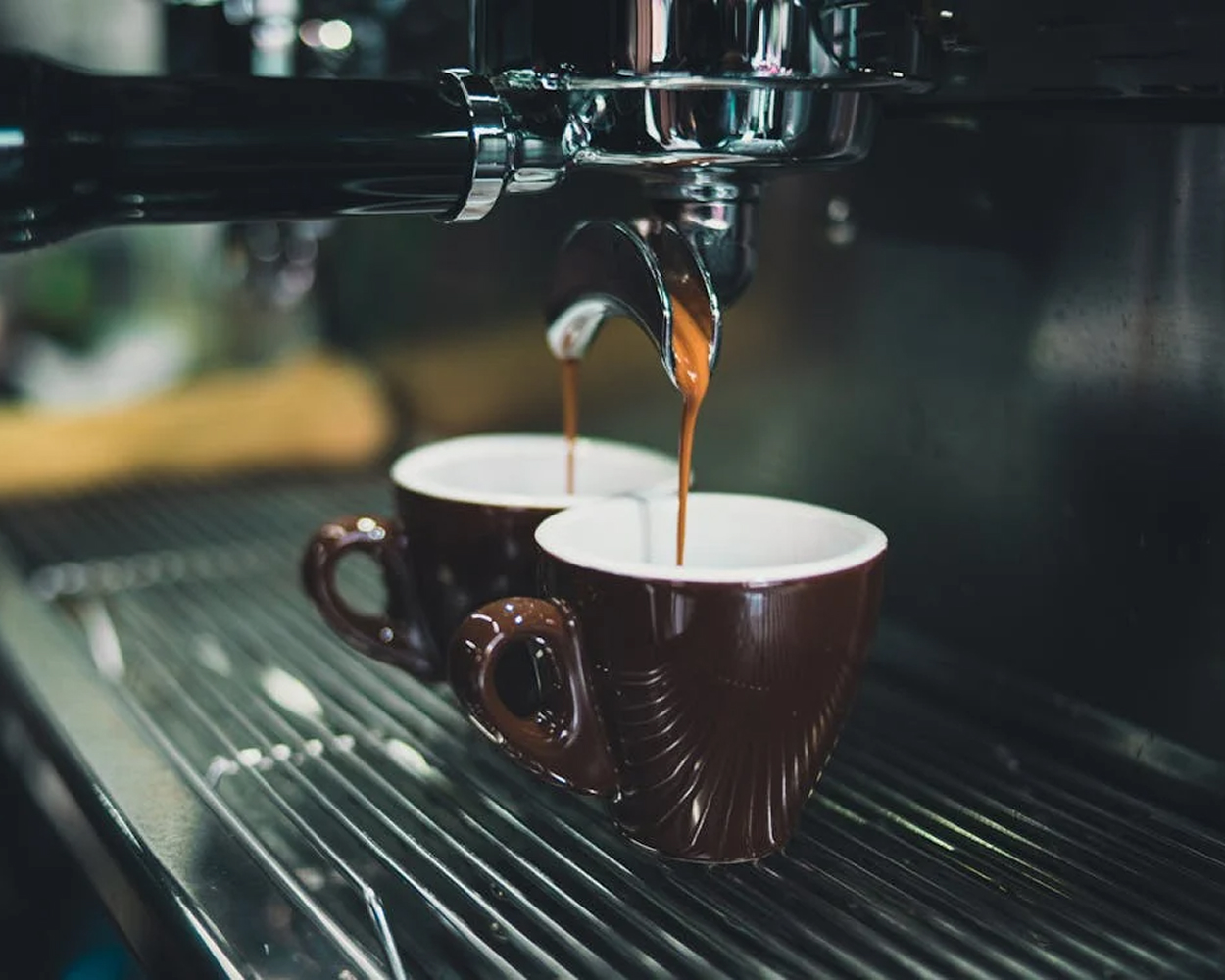 Zwei Tassen unter einer Kaffeemaschine