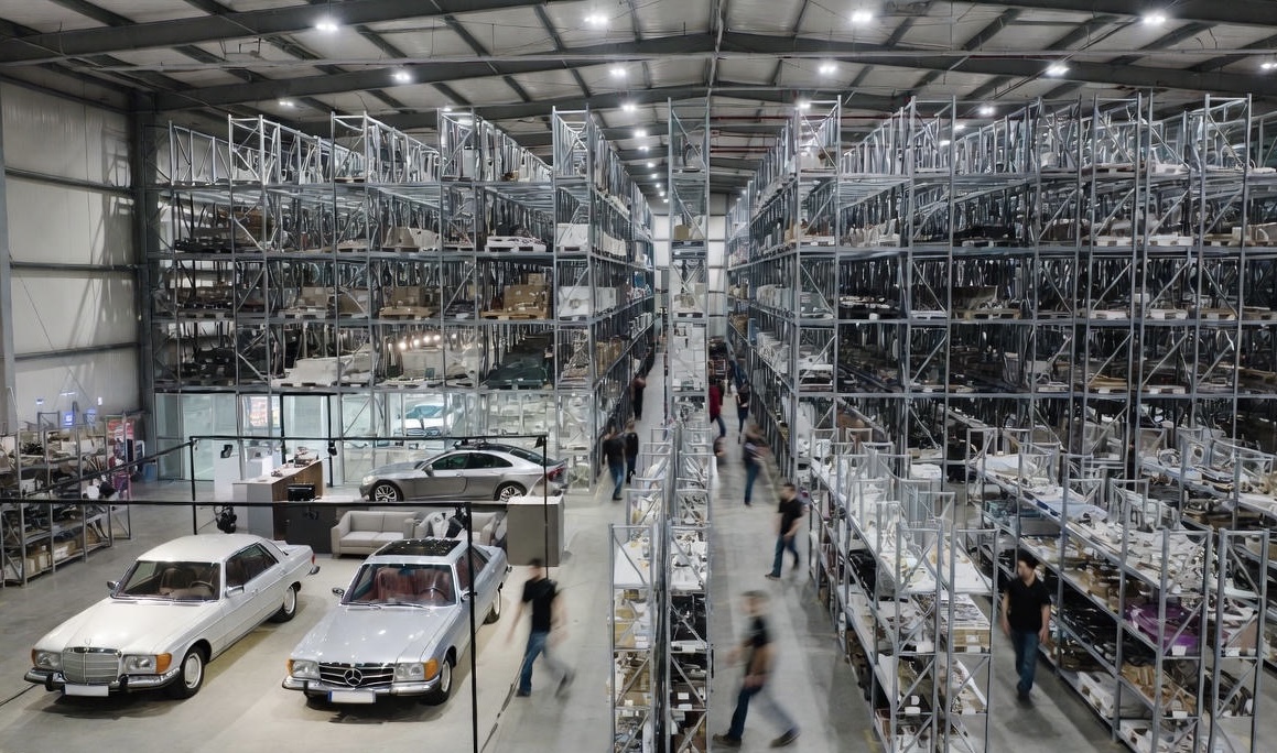 Mercedes-Benz SUV steht in einer sonnigen Einfahrt, umgeben von Pflanzen und einem modernen Haus im Hintergrund.