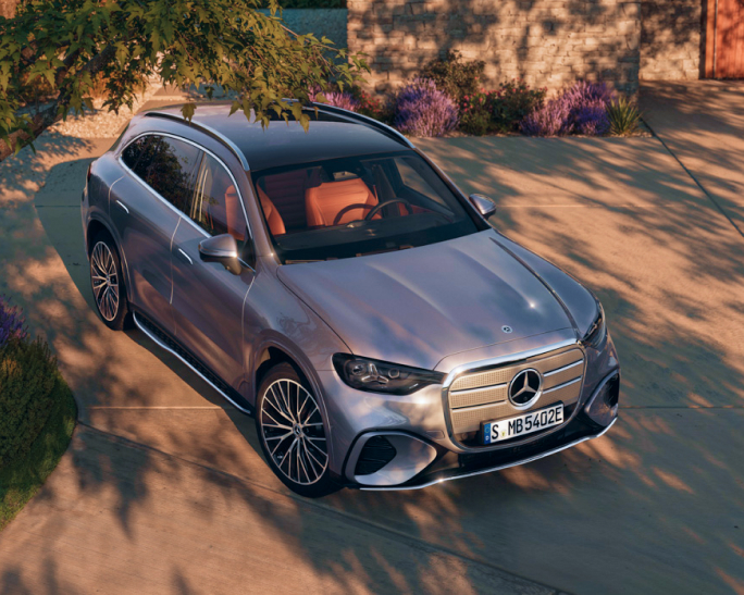 Referenz Hirschvogel Autoteile Mood Mercedes-Benz SUV steht in einer sonnigen Einfahrt, umgeben von Pflanzen und einem modernen Haus im Hintergrund.
