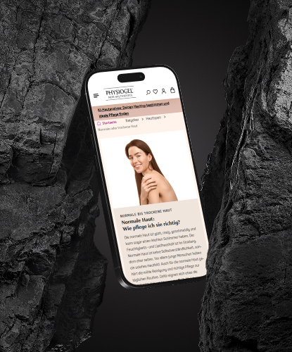 Ein Smartphone ist in einen Vordergrund mit Steinen eingebunden. Auf dem Bildschirm des Smartphones ist der PHYSIOGEL-Shop abgebildet.
