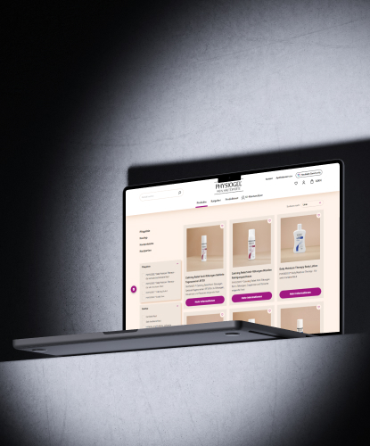 Ein Laptop schwebt vor dunklem Hintergrund im Lichtkegel. Auf dem Bildschirm ist die PHYSIOGEL-Website zu sehen.