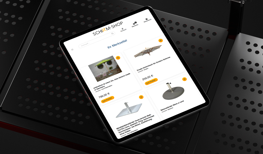 Shirm-Shop Referenz Mockup Tablet Ein Tablet liegt auf einer düsteren Oberfläche. Auf dem Bildschirm des Tablets ist die Shirm-Shop-Website abgebildet.