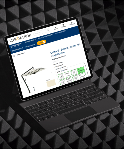 Shirm-Shop Referenz Mockup Tablet Ein Tablet steht quer auf einem dunkelen Untergrund. Auf dem Bildschirm des Tablets ist die Shirm-Shop-Website abgebildet.