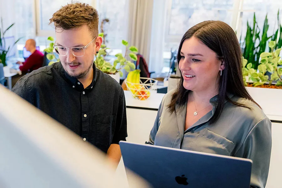 KI in der Webentwicklung für messbare digitale Vorteile Zwei Web-Experten besprechen gemeinsam eine KI-gestützte Weblösung am Laptop