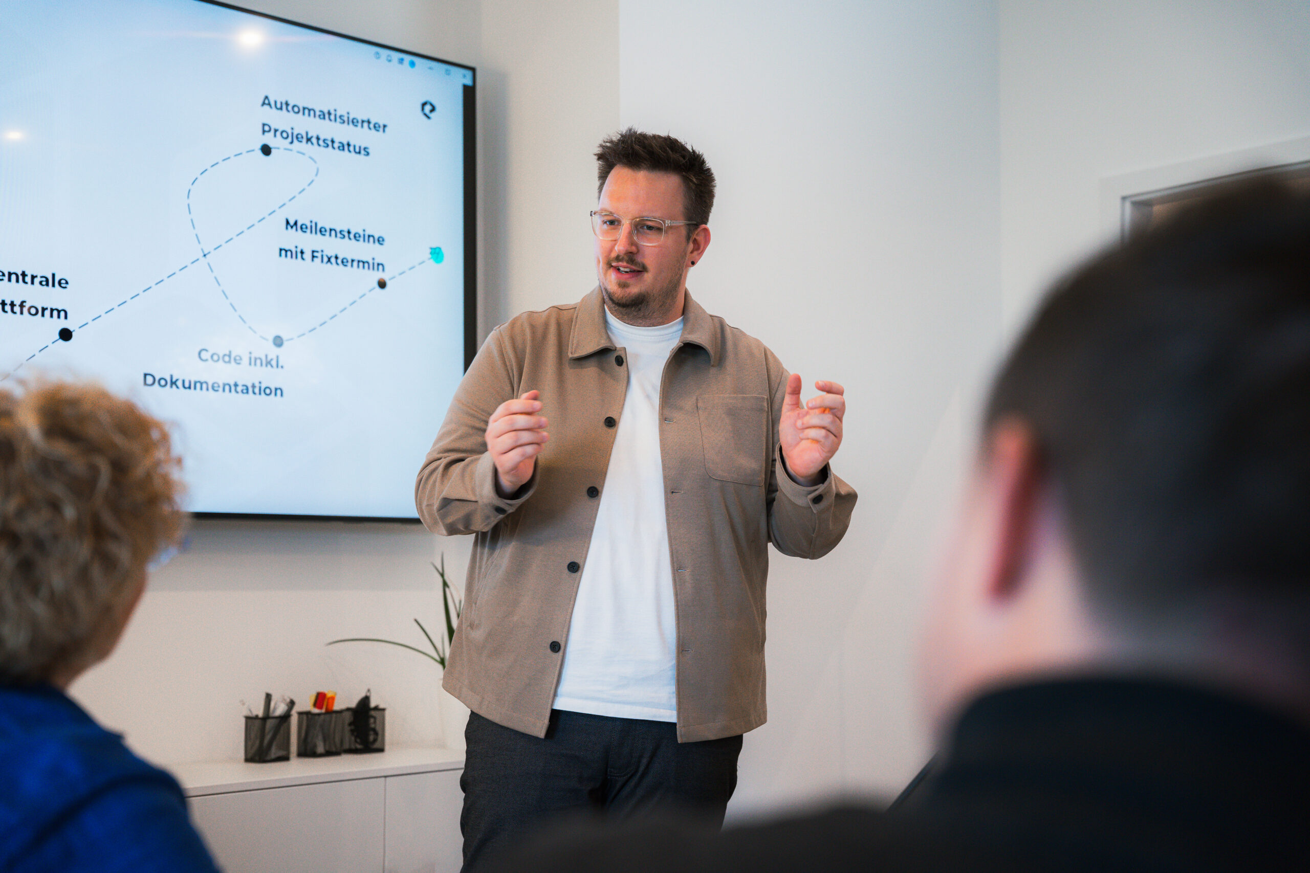 Ein Mann redet vor einem Bildschirm in der WordPress-Agentur Stuttgart.