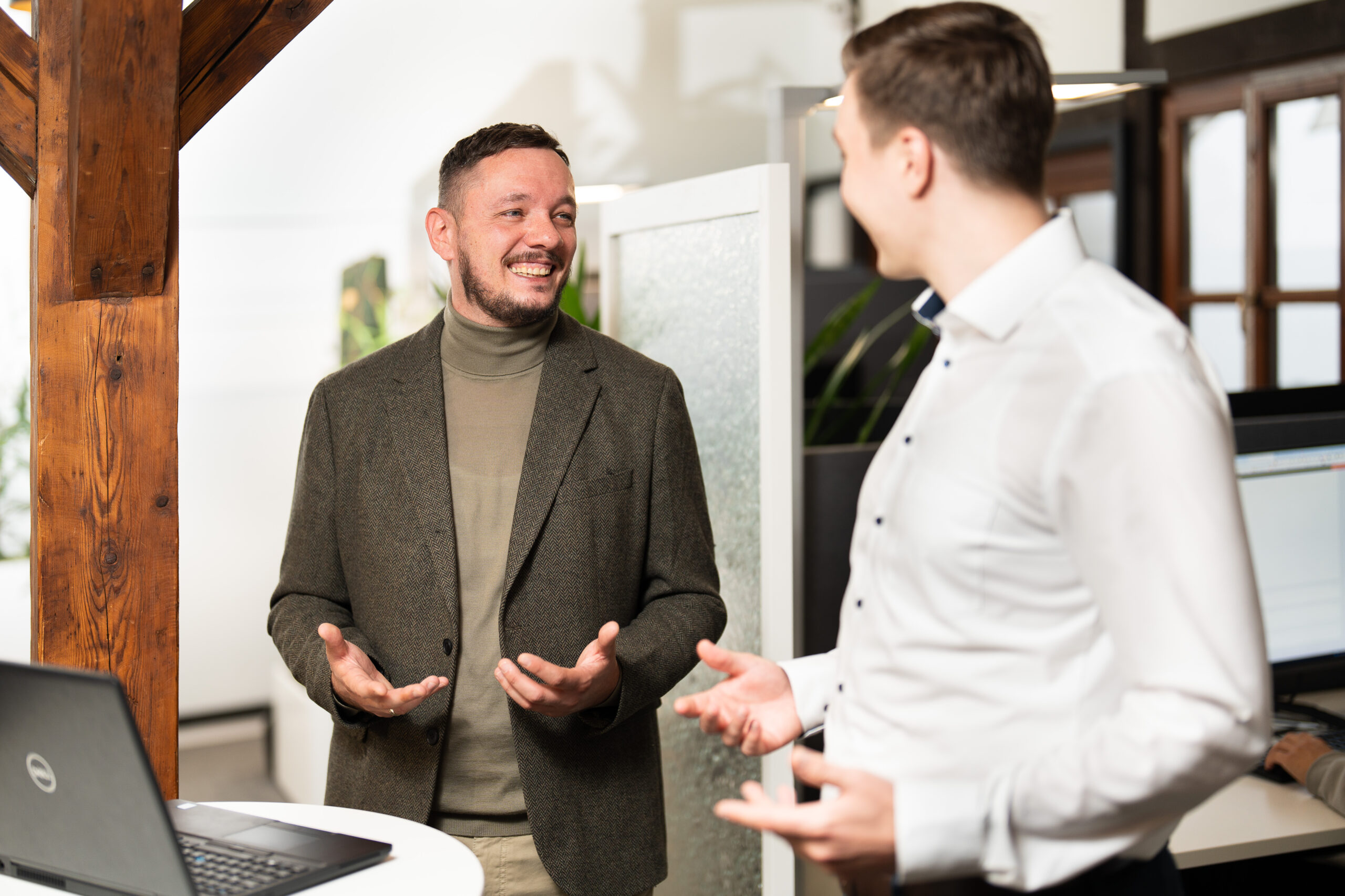 Shopware-Branchen Zwei Männer führen ein Gespräch im Büro und tauschen sich über Strategien und Lösungen für unterschiedliche Shopware-Branchen aus.