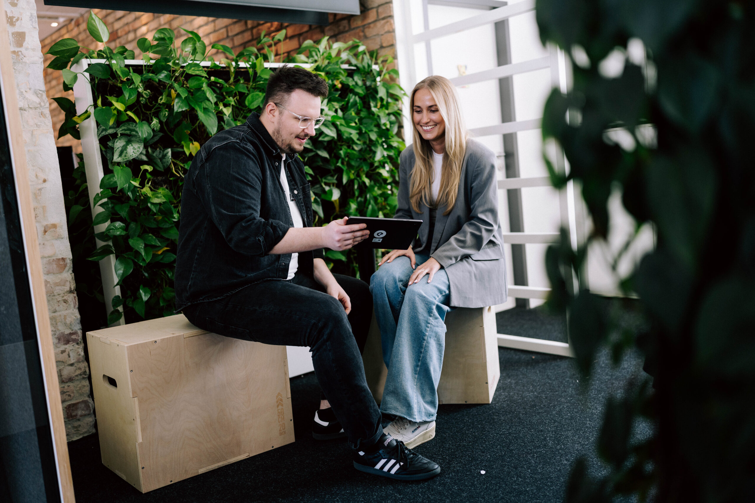 KI im E-Commerce Zwei Mitarbeitende besprechen am Tablet den strategischen Einsatz von KI im E-Commerce.