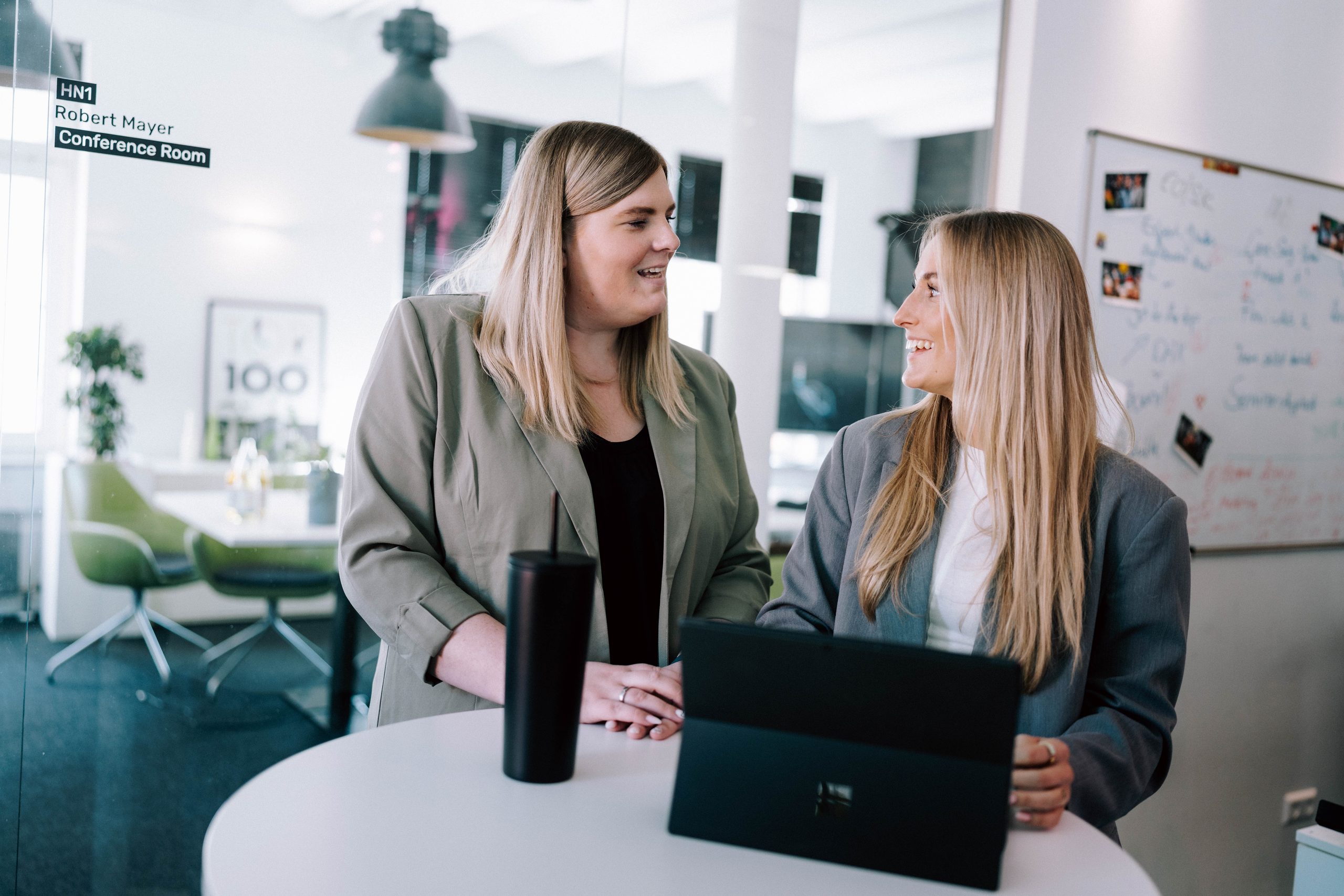 Persönliche Online-Marketing-Beratung für Unternehmen in Zürich Zwei Mitarbeiterinnen im Gespräch über ein digitales Projekt am Laptop