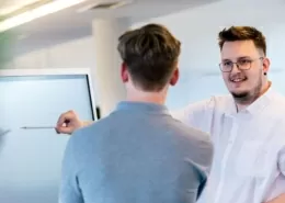 Mitarbeiter beraten sich vor einem Whiteboard