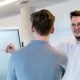 Mitarbeiter beraten sich vor einem Whiteboard