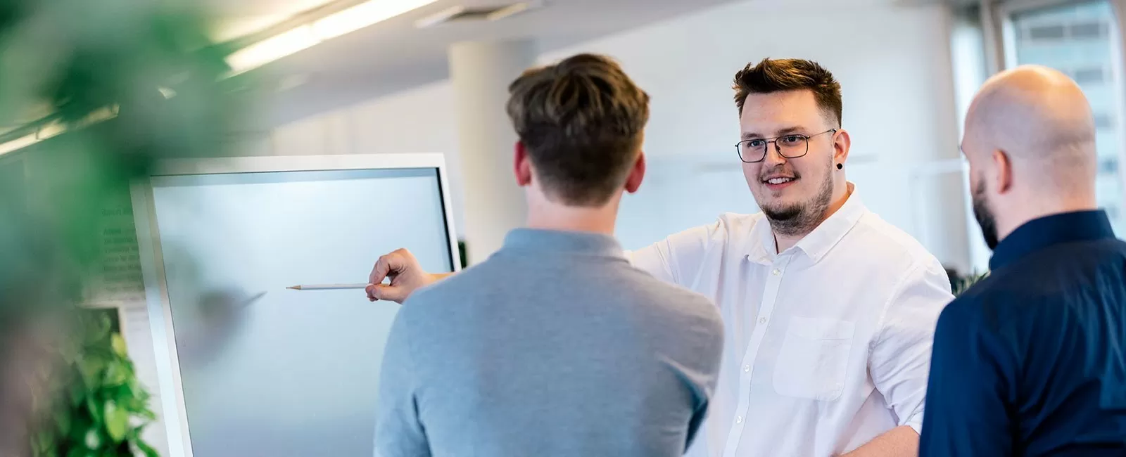 Mitarbeiter beraten sich vor einem Whiteboard