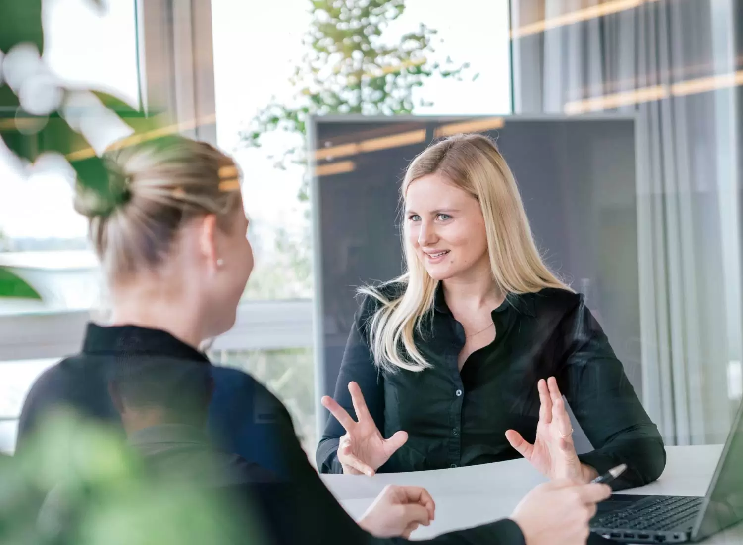 Zwei Menschen sitzen an einem Besprechungstisch im Büro