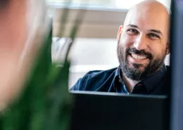 Shopware-Entwickler lächelt vor Computer