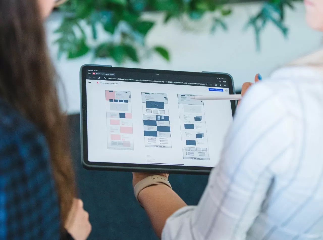 Foto von einem Online Wireframe in Invision auf einem Tablet mit Personen, die es besprechen