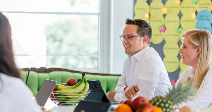 Personen sitzen in einem Konferenzraum und besprechen ein weiteres Vorgehen.