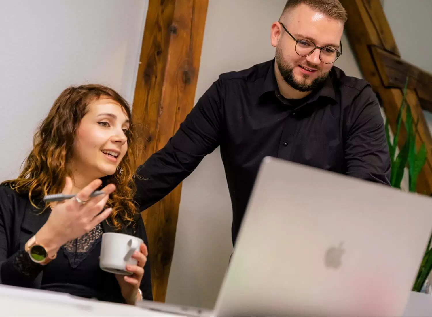 Junge Frau und Mann schauen auf einen Laptop